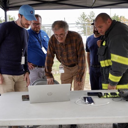RedLab team and a firefighter in turnout gear reviewing tracking results at the FRST Challenge final competition